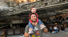 Marketing brand manager holding son smiling in Disneyland